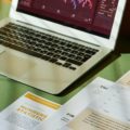 A laptop and document showing statistic charts
