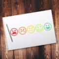 A notepad with feedback smiley faces drawn on it